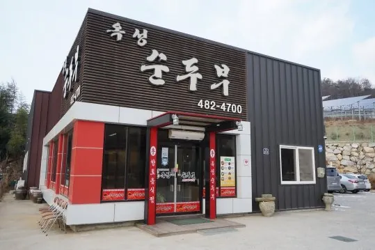옥성순두부 외관 — 간판, 빨간 문틀, 앞마당 주차장