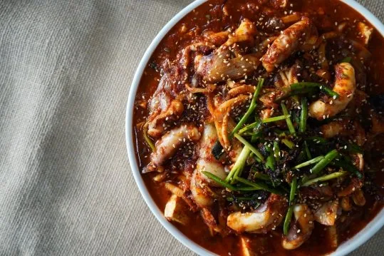 낙지두부두루치기 — 붉은 양념 위 깨와 부추